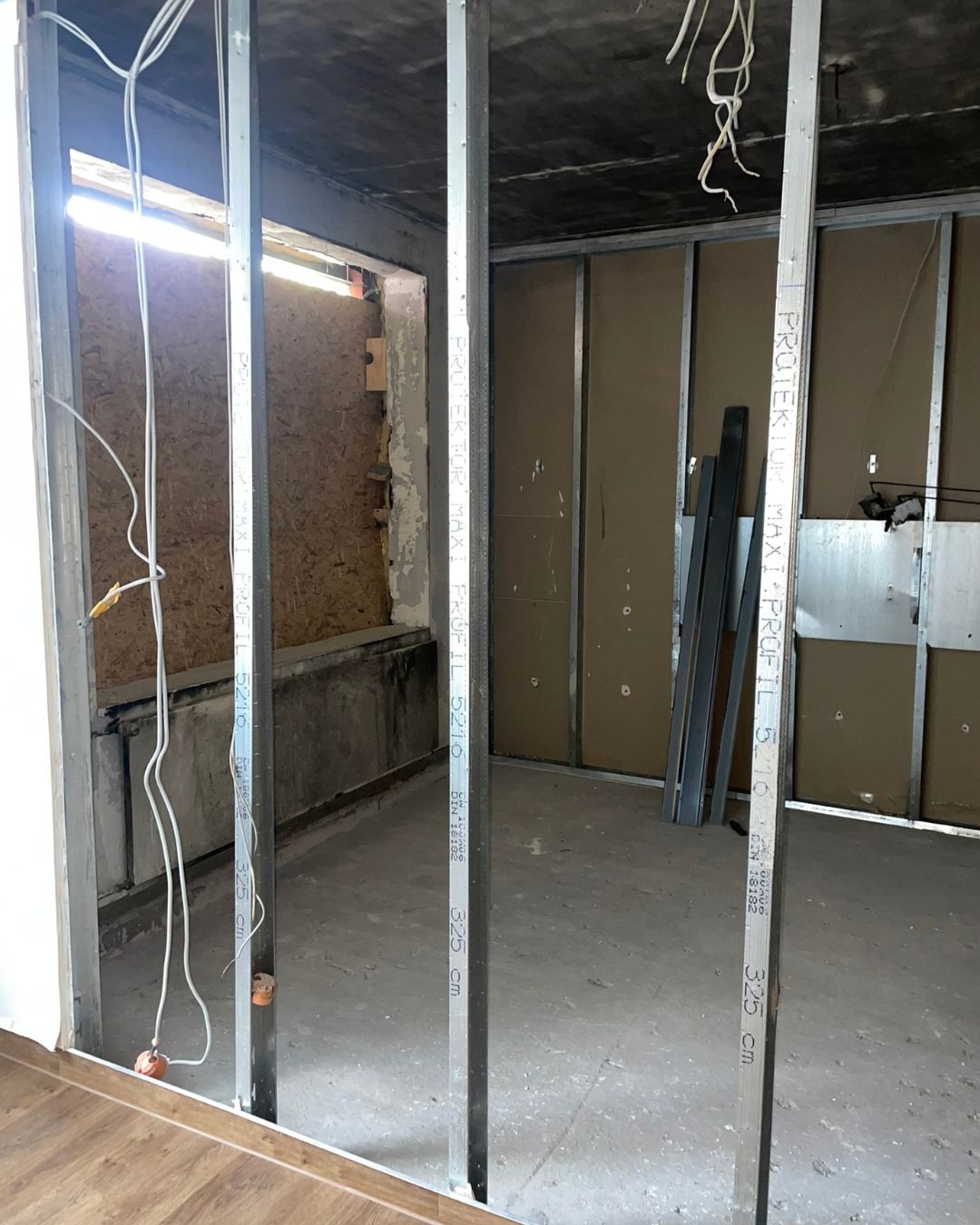 Metallständerwerk für neue Wände im entkernten Brandzimmer, im Hintergrund das verschlossene Fenster